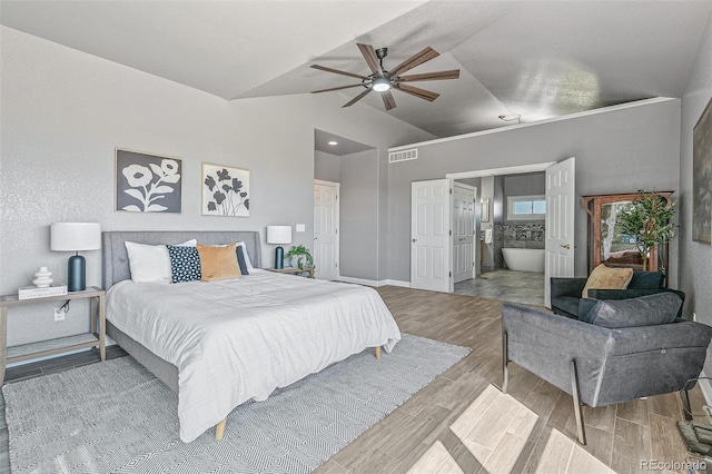 bedroom with ceiling fan, ensuite bathroom, and vaulted ceiling