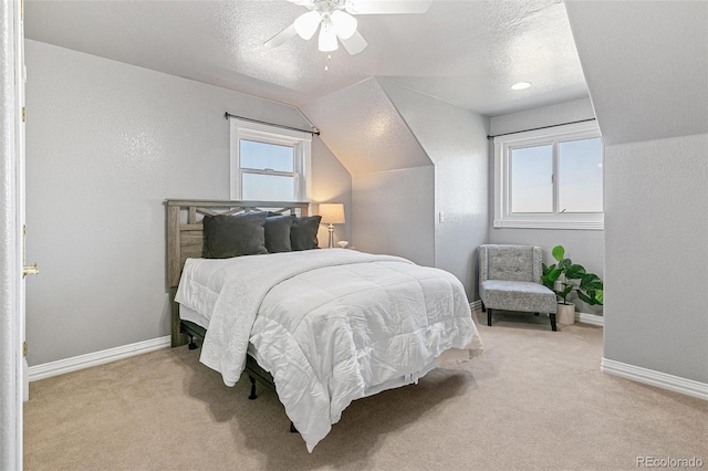 carpeted bedroom featuring ceiling fan, lofted ceiling, a textured ceiling, and multiple windows