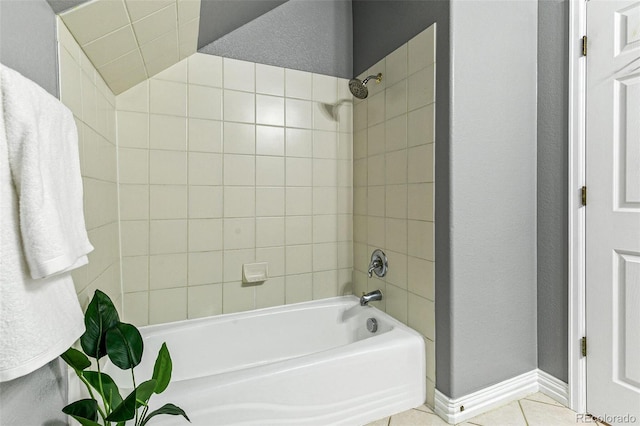 bathroom featuring tiled shower / bath combo and tile patterned flooring