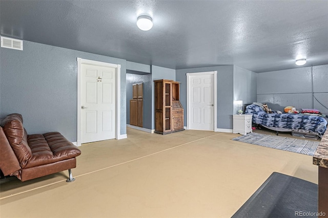 bedroom with a textured ceiling and concrete flooring