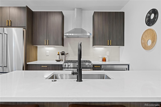 kitchen with stove, high end fridge, tasteful backsplash, dark brown cabinetry, and wall chimney exhaust hood