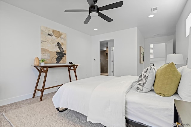 bedroom featuring ensuite bath, light colored carpet, and ceiling fan