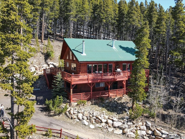 451 Harris Dr, Idaho Springs, CO 80452 - view of front of home featuring a wooden deck, metal roof, a view of trees, and log exterior