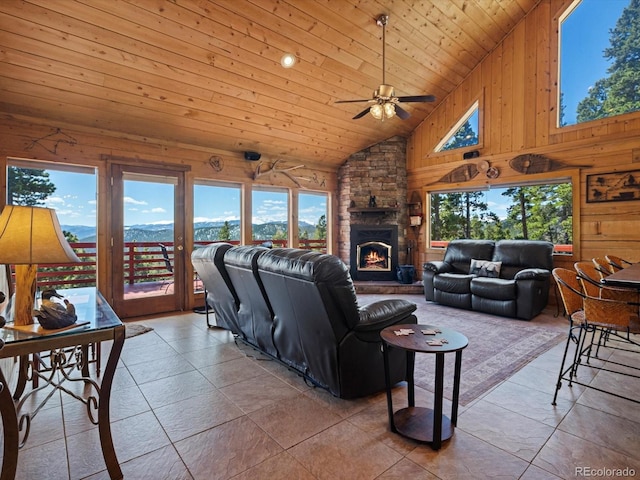 451 Harris Dr, Idaho Springs, CO 80452 - tiled living room featuring wooden ceiling, ceiling fan, a fireplace, wooden walls, and a mountain view