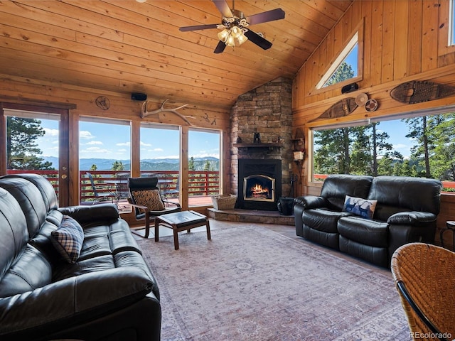 451 Harris Dr, Idaho Springs, CO 80452 - living area featuring healthy amount of natural light, wooden walls, a mountain view, ceiling fan, and vaulted ceiling