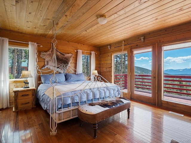 451 Harris Dr, Idaho Springs, CO 80452 - bedroom with wooden ceiling, wood-type flooring, access to exterior, a mountain view, and wood walls