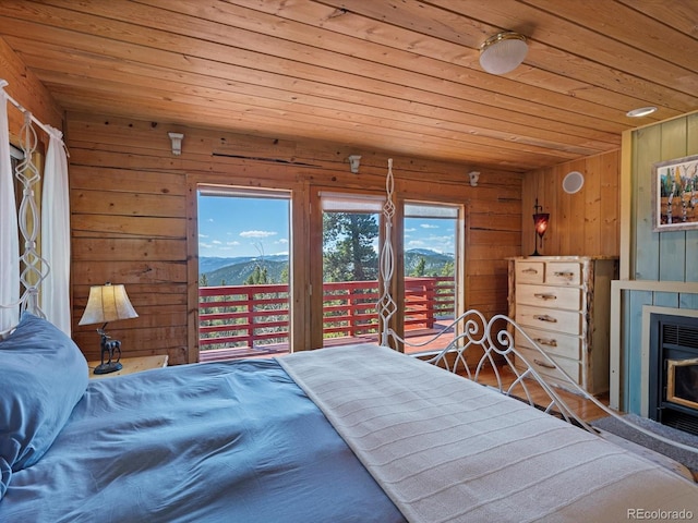 451 Harris Dr, Idaho Springs, CO 80452 - bedroom featuring wood ceiling, access to exterior, multiple windows, wooden walls, and a fireplace