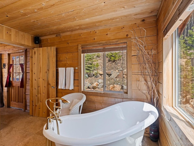 451 Harris Dr, Idaho Springs, CO 80452 - bathroom featuring wooden walls, wood ceiling, a freestanding tub, and tile patterned floors