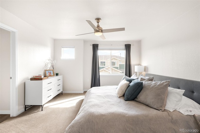 bedroom with ceiling fan, baseboards, and light carpet