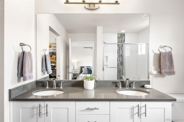 bathroom featuring a sink, double vanity, ensuite bath, and a shower stall