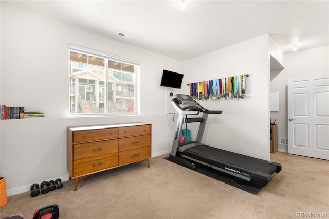 workout area featuring visible vents, light carpet, and baseboards