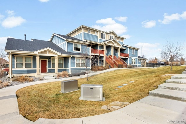 view of front of property featuring a shingled roof and a front lawn