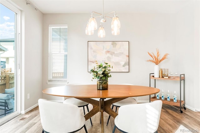 dining room with a chandelier and light hardwood / wood-style flooring