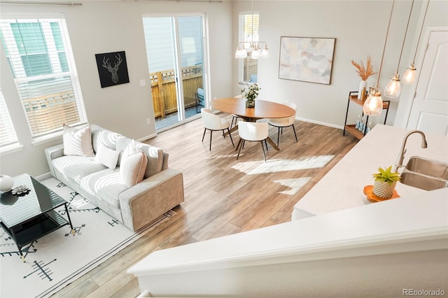 living room with wood-type flooring, a notable chandelier, and sink