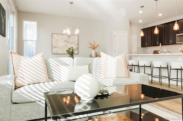 living room with hardwood / wood-style flooring and an inviting chandelier