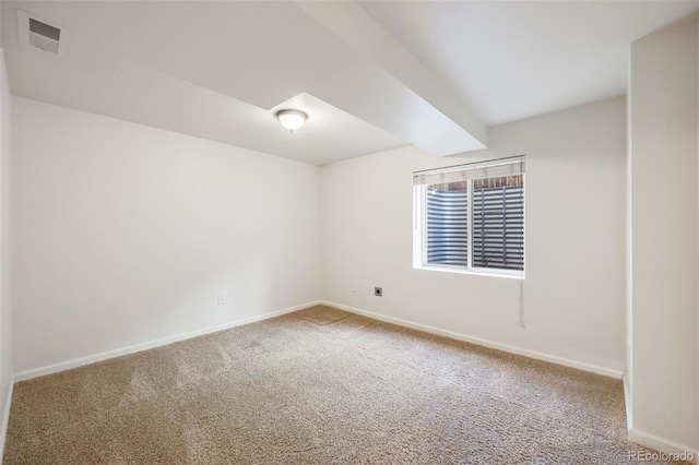 carpeted spare room with beam ceiling