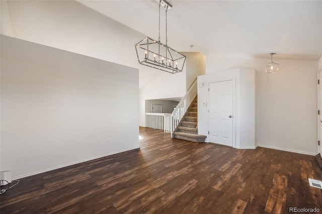 unfurnished living room with dark hardwood / wood-style flooring and vaulted ceiling