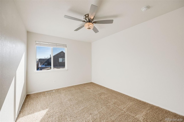 carpeted spare room with ceiling fan