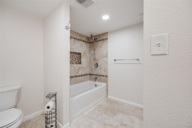 bathroom with tiled shower / bath combo and toilet