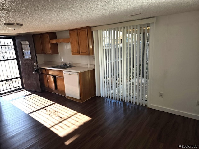 kitchen with dark hardwood / wood-style flooring, dishwasher, a textured ceiling, and sink