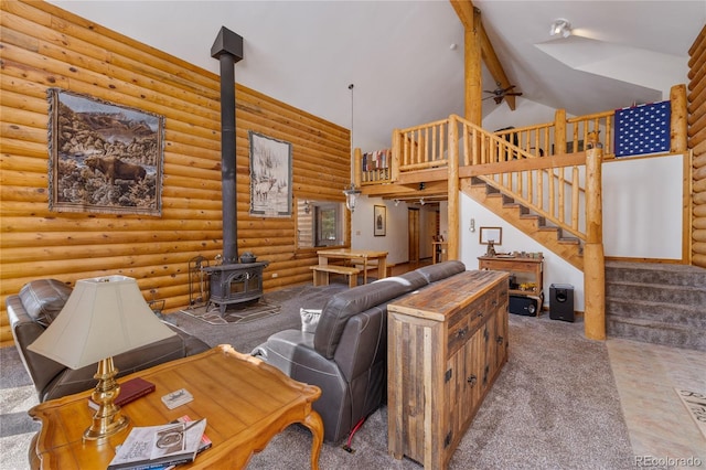 carpeted living area featuring beam ceiling, log walls, stairs, high vaulted ceiling, and a wood stove