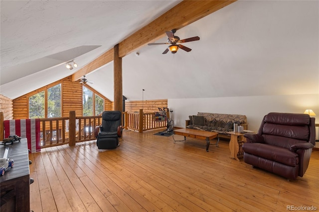 interior space featuring ceiling fan, rustic walls, vaulted ceiling with beams, and light wood-style floors