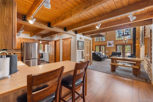 kitchen with track lighting, wood ceiling, tile counters, and freestanding refrigerator