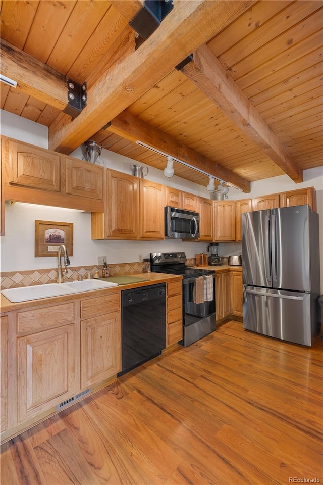 kitchen with wood ceiling, appliances with stainless steel finishes, a sink, and beamed ceiling