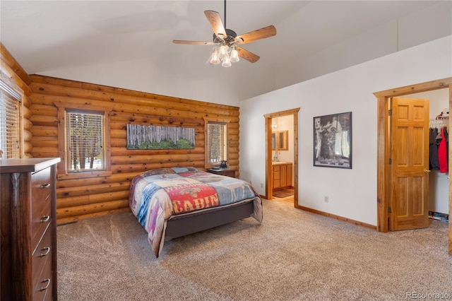 bedroom with rustic walls, baseboards, light colored carpet, lofted ceiling, and connected bathroom