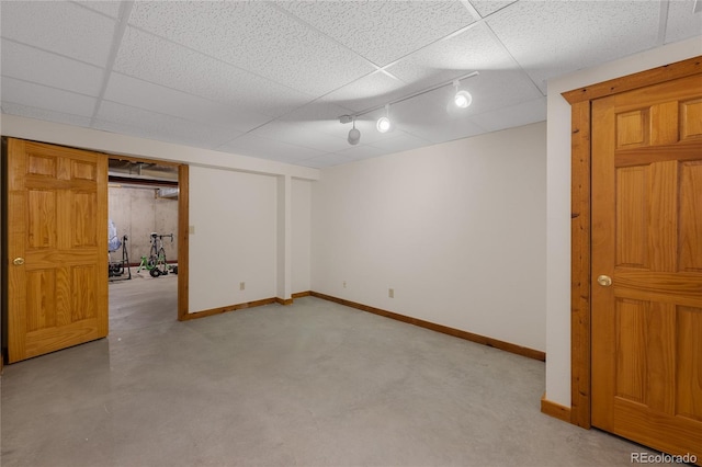 finished basement with rail lighting and baseboards