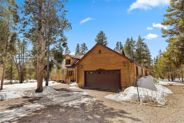 view of front facade featuring an attached garage and log exterior