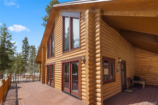 view of side of property featuring log exterior and a deck