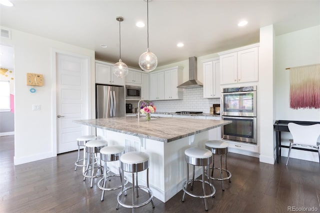 11880 W 38th Pl, Wheat Ridge, CO 80033 - kitchen with wall chimney exhaust hood, appliances with stainless steel finishes, dark wood-style flooring, decorative backsplash, and a kitchen bar