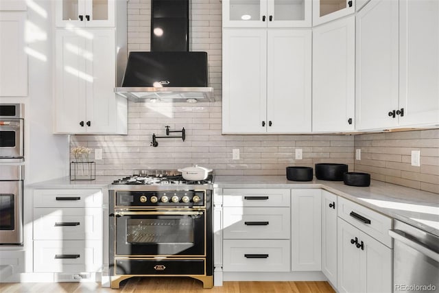 kitchen featuring gas stove, light stone countertops, white cabinets, dishwasher, and wall chimney exhaust hood