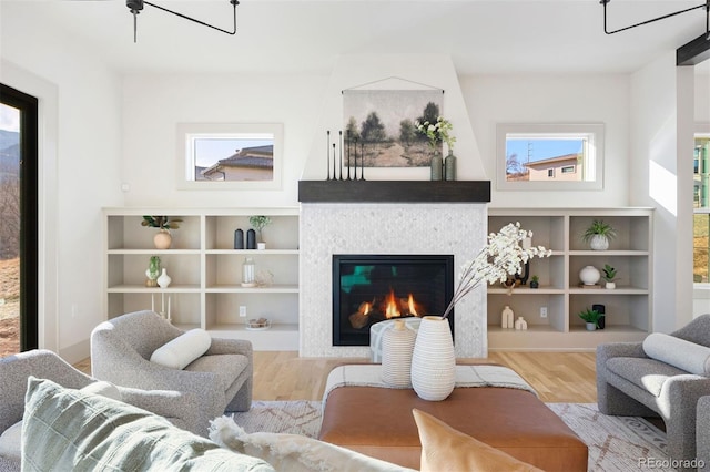 living room featuring a tiled fireplace and wood finished floors