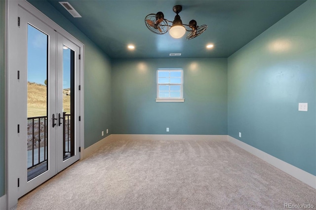 carpeted spare room featuring recessed lighting, french doors, baseboards, and a chandelier