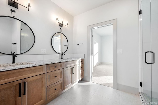 full bathroom featuring tile patterned flooring, a shower stall, double vanity, and a sink