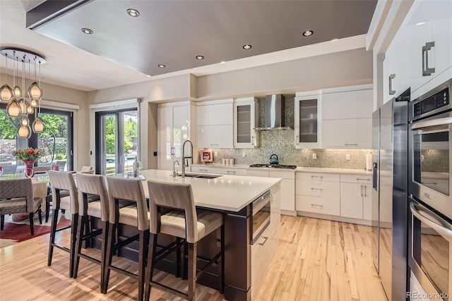 9470 S Silent Hills Dr, Lone Tree, CO 80124 - kitchen featuring wall chimney range hood, a sink, modern cabinets, white cabinetry, and recessed lighting