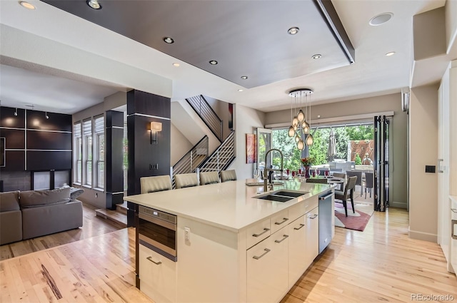 9470 S Silent Hills Dr, Lone Tree, CO 80124 - kitchen featuring a sink, open floor plan, light wood-style floors, built in microwave, and pendant lighting
