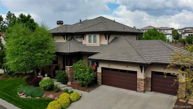 9470 S Silent Hills Dr, Lone Tree, CO 80124 - view of front of home featuring stucco siding, driveway, stone siding, and a garage