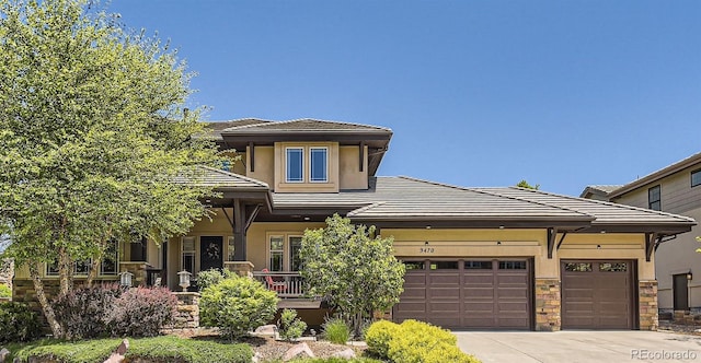 9470 S Silent Hills Dr, Lone Tree, CO 80124 - prairie-style home with driveway, stone siding, stucco siding, and an attached garage