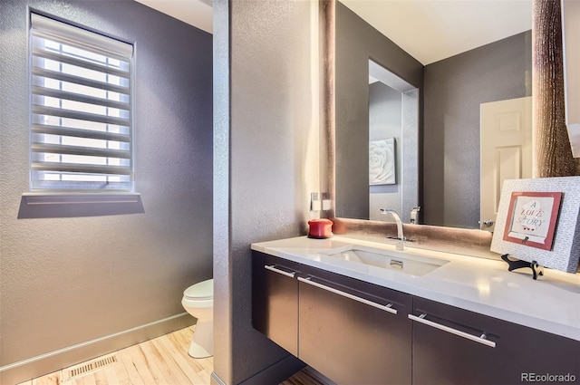 9470 S Silent Hills Dr, Lone Tree, CO 80124 - half bath featuring a textured wall, toilet, wood finished floors, vanity, and baseboards