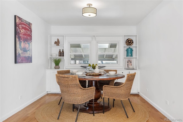 dining area featuring built in features and light hardwood / wood-style floors