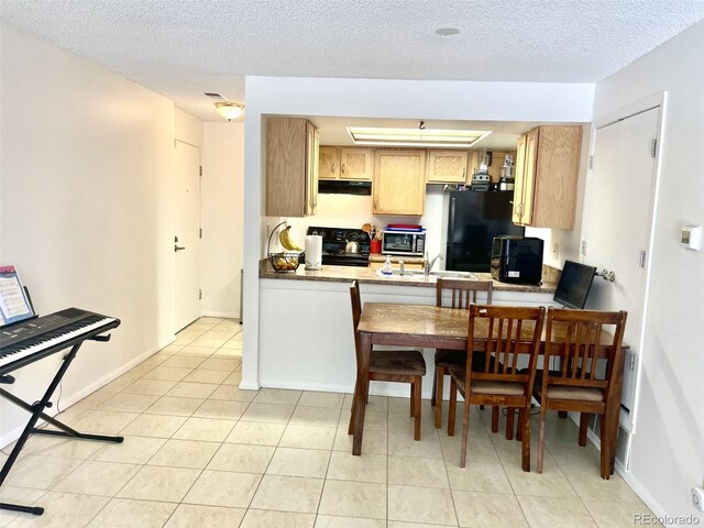 4281 S Salida Way Unit 5, Aurora, CO 80013 - kitchen featuring stove, under cabinet range hood, freestanding refrigerator, a sink, and light tile patterned flooring