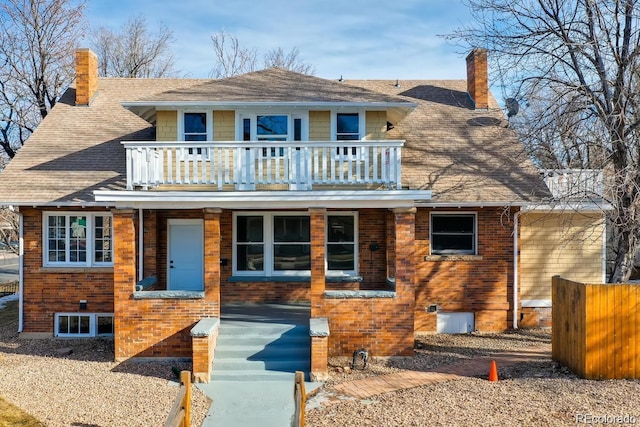 1602 11th Ave, Greeley, CO 80631 - view of front facade with a balcony, a chimney, brick siding, and a shingled roof