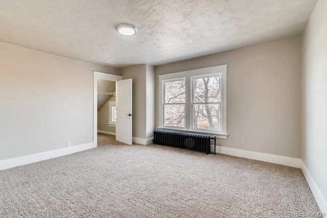 1602 11th Ave, Greeley, CO 80631 - unfurnished bedroom featuring radiator heating unit, carpet floors, multiple windows, and a textured ceiling