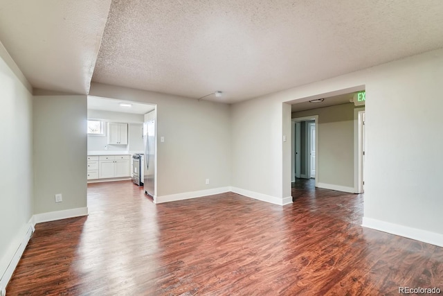 1602 11th Ave, Greeley, CO 80631 - unfurnished living room with dark wood-style floors, a textured ceiling, and baseboard heating