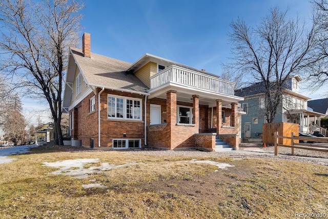 1602 11th Ave, Greeley, CO 80631 - view of front facade featuring a balcony, a chimney, brick siding, and roof with shingles