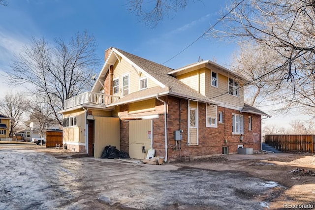 1602 11th Ave, Greeley, CO 80631 - view of home's exterior with a balcony, brick siding, and roof with shingles