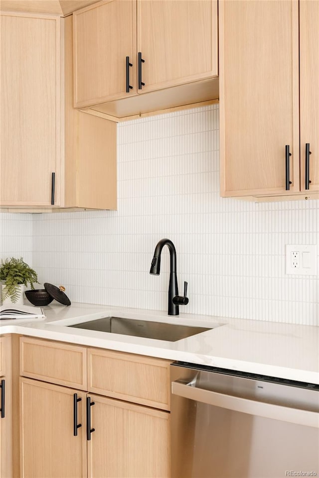 kitchen with stainless steel dishwasher, light brown cabinetry, and sink